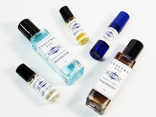 Six colorful bottles of men's cologne oil in different sizes. Dram, 10ml, and 1oz.