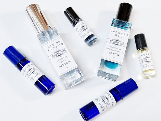 Six colorful bottles of men's cologne oil in different sizes. Dram, 10ml, and 1oz.