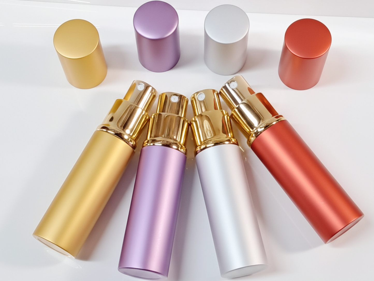 Set of colorful metal spray bottles on a white background