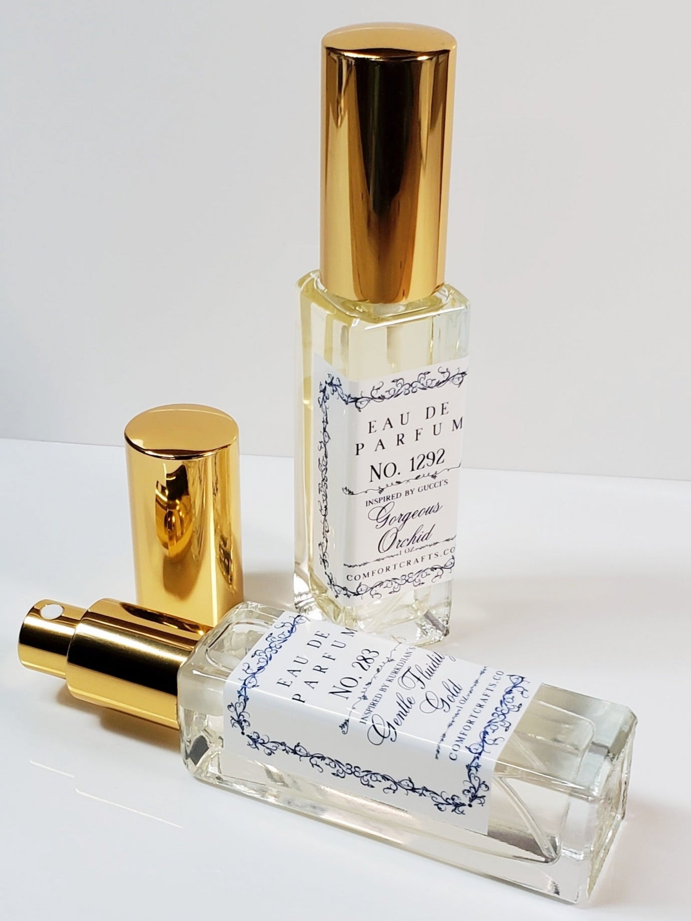 2 tall rectangle shaped perfume bottles with gold sprayers