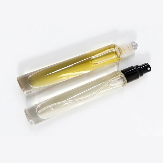 Two clear glass rollerball and spray perfume bottles with black caps, labeled Tobacco Leaf & Tonka by Comfort Crafts, on a clean white background.